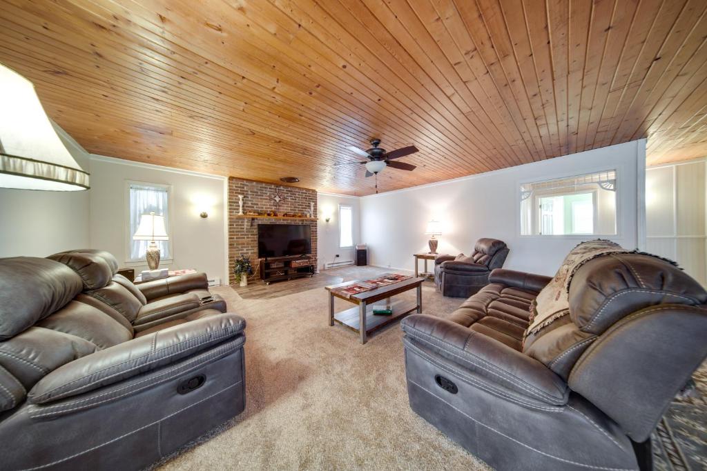 un soggiorno con mobili in pelle e soffitto in legno di North Jackson Vacation Rental with Wraparound Deck! 