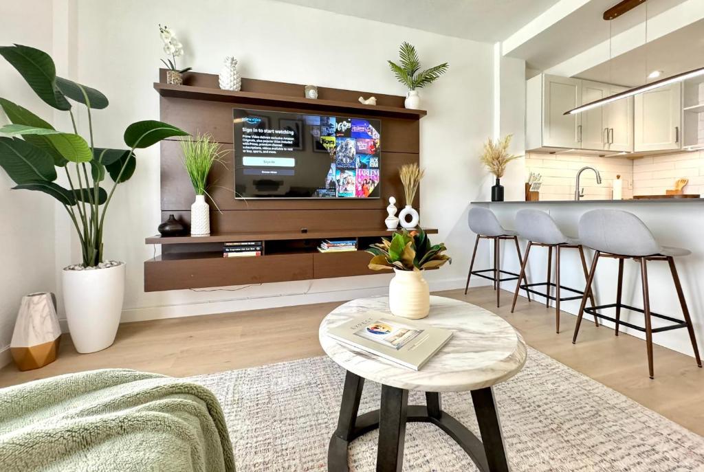 a living room with a tv and a kitchen at High-End Apartment, Across the Beach in Miami Beach