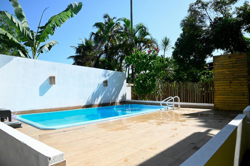 a swimming pool in a backyard with a wooden deck at Pousada Caminho da Concha in Itacaré