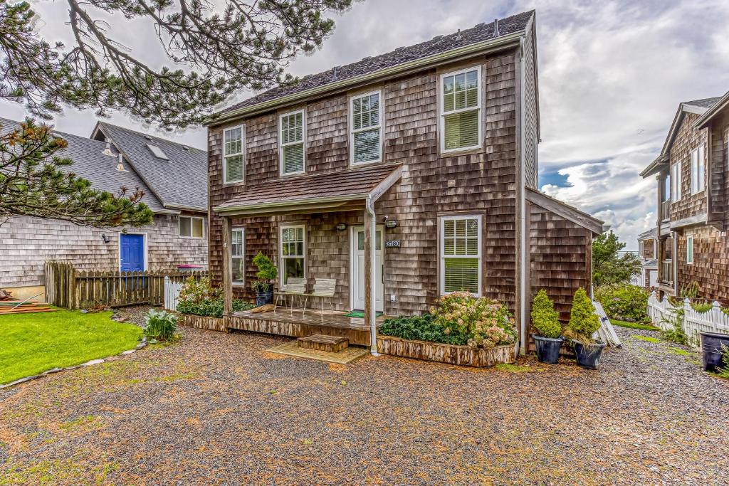 a brick house with a driveway in front of it at Cannon Beach Saltbox Cottage in Cannon Beach