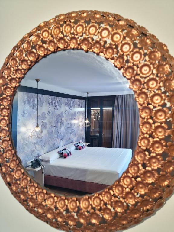 um espelho com uma cama num quarto em Hotel Suites Moma Centro em Villanueva de la Serena
