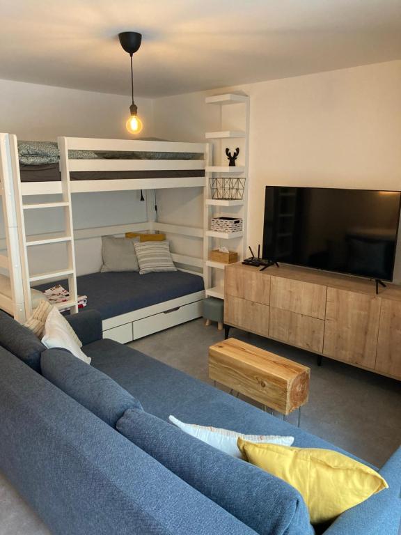 a living room with two bunk beds and a blue couch at Apartmán U Jelena in Jablonec nad Nisou