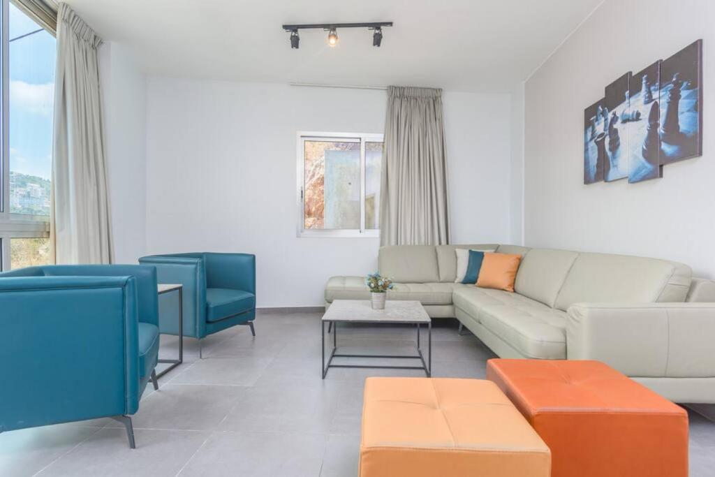 uma sala de estar com um sofá e cadeiras em Vibe 305, Modern 2Bedroom Apartment in Awkar em Dbayeh