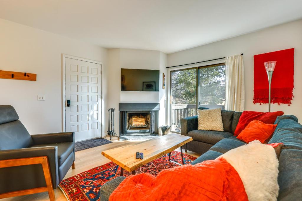 ein Wohnzimmer mit Sofas, einem Tisch und einem Kamin in der Unterkunft Walk to Winter Park Bus From Fraser Condo! in Fraser