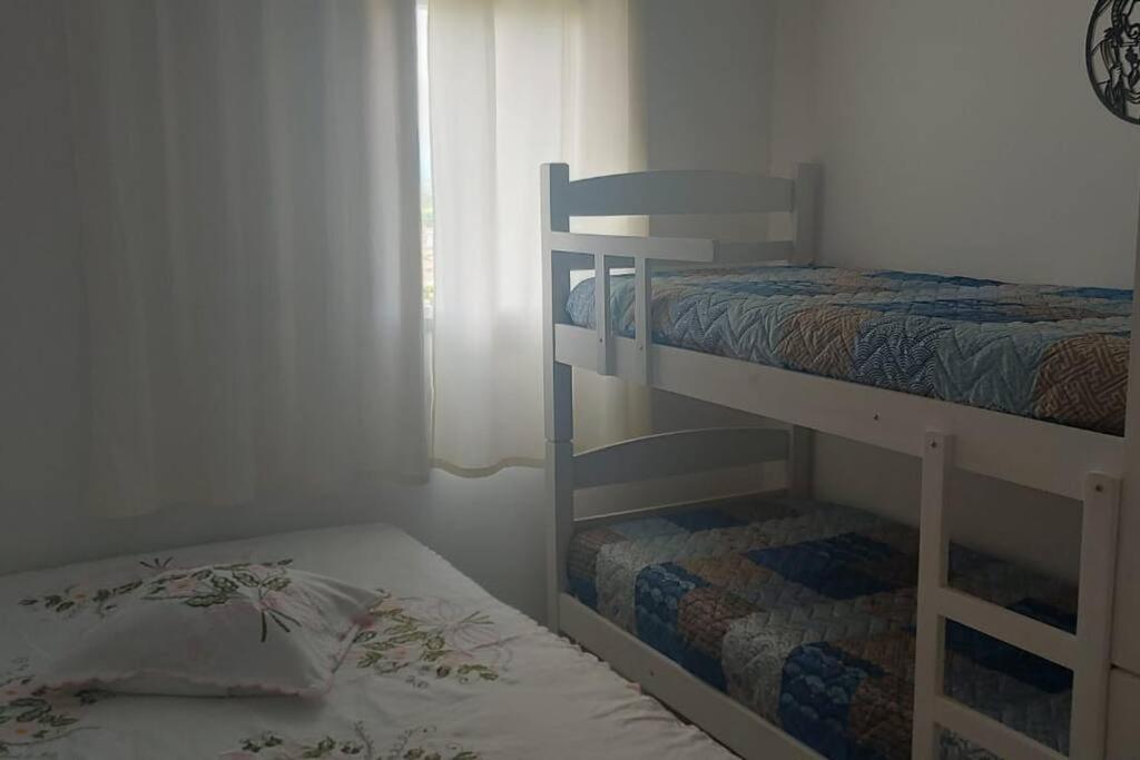 - une chambre avec 2 lits superposés et une fenêtre dans l'établissement Ap. Condominio da Fé c/ Garagem e Ar Condicionado, à Cachoeira Paulista