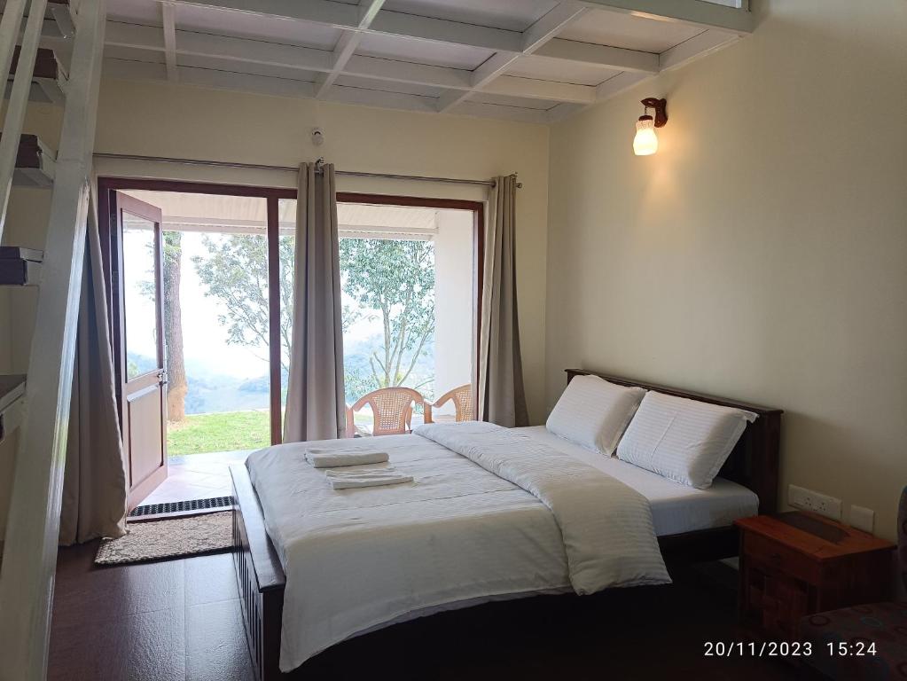 a bedroom with a bed and a large window at Moksha Infinity Valley in Kotagiri
