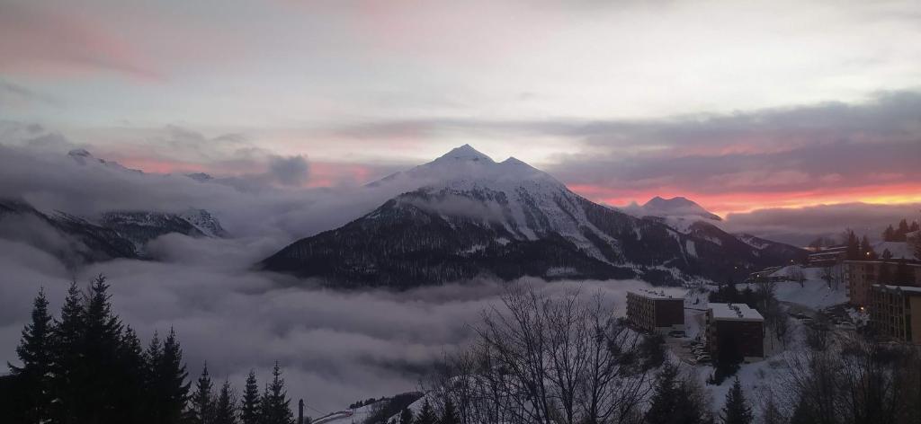 une montagne couverte de nuages avec une montagne dans l'établissement haute montage station Orcières merlette draps-ménage en supp sur demande, à Orcières