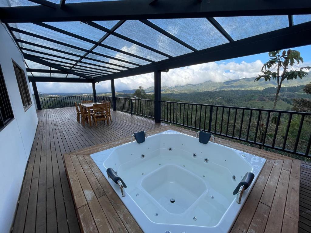 a hot tub on a deck with a view of the mountains at Mirador la piedra in Guatapé