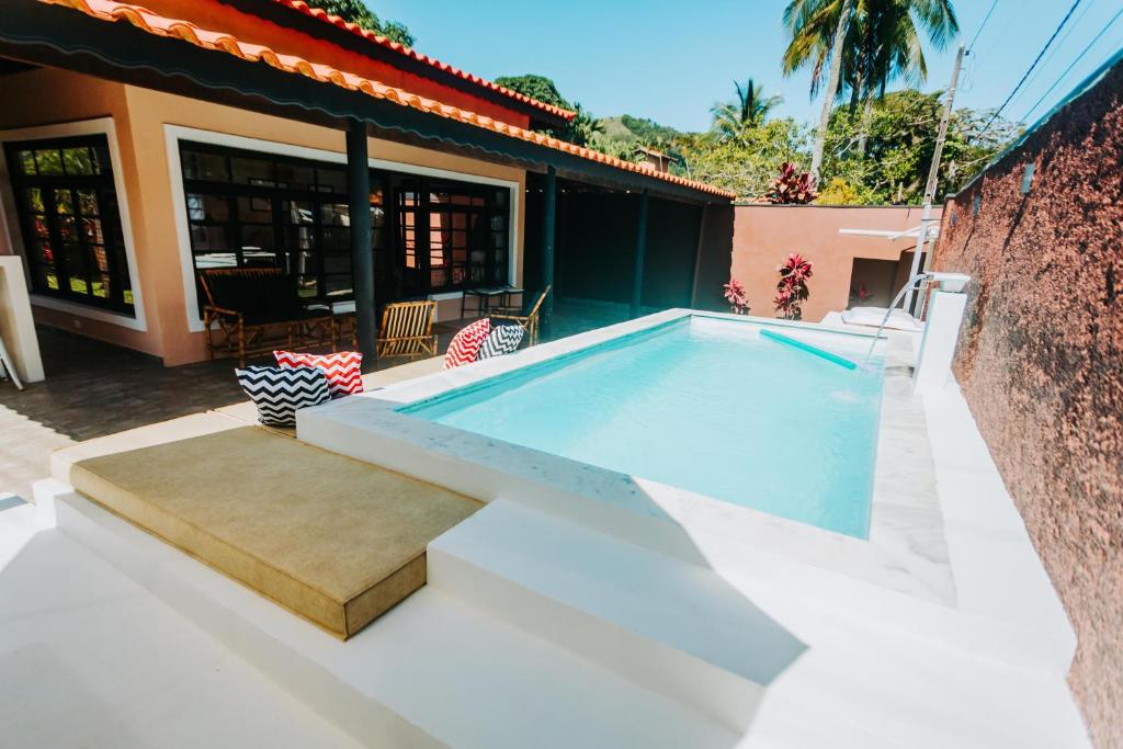 a swimming pool in the backyard of a house at Casa c/ Piscina e Área Gourmet Perto da Praia in São Sebastião