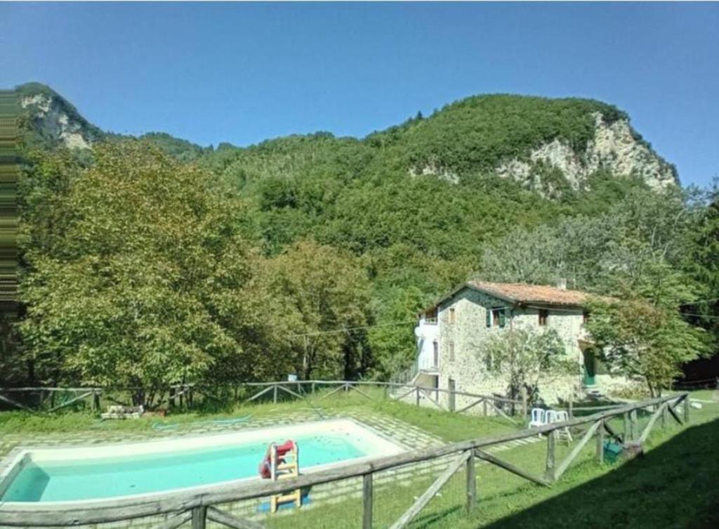 uma casa com piscina em frente a uma montanha em Luxury suite la Grotta del Vento em Gallicano