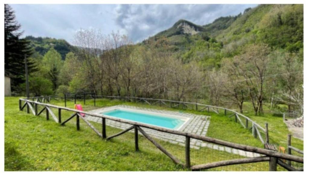- une piscine au milieu d'un champ avec des montagnes dans l'établissement Casa Vacanza La Grotta, à Gallicano