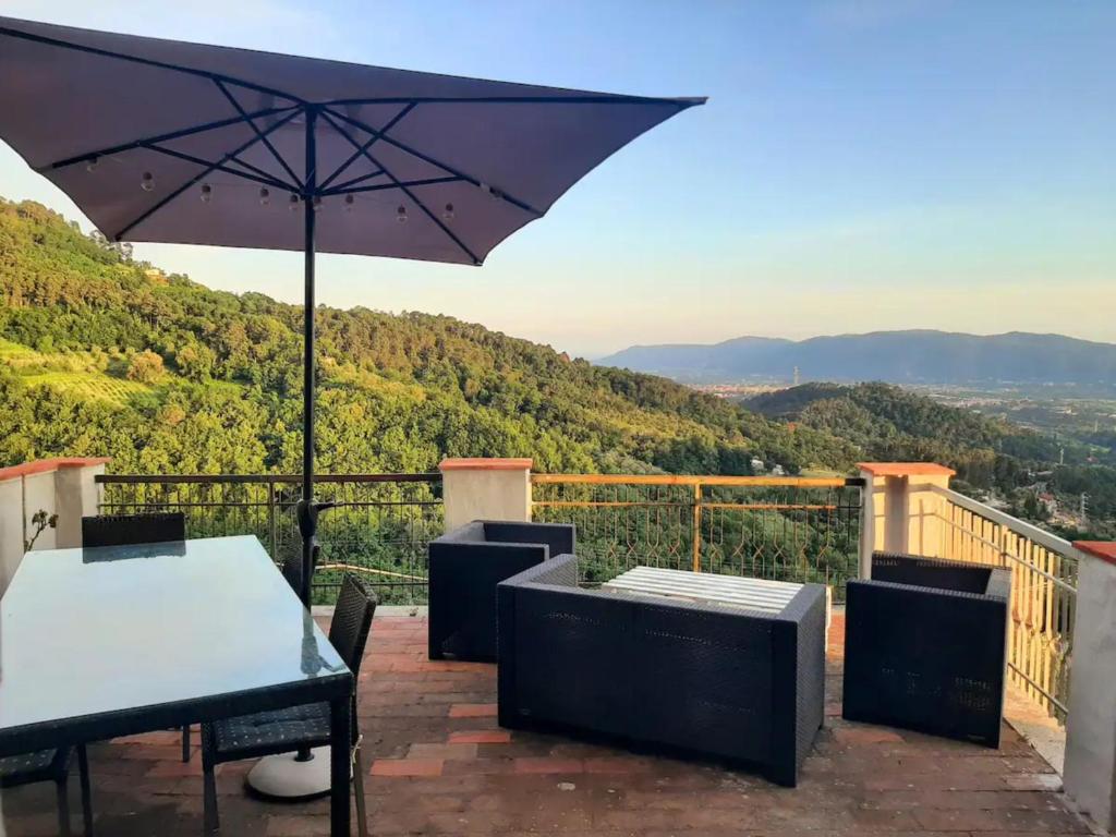 une terrasse avec une table et un parasol dans l'établissement Luxury suite La Torretta, à Sarzana