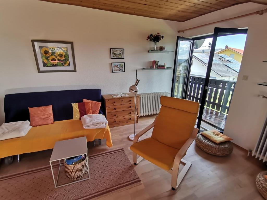 a living room with a bed and a chair at Ferienwohnung am Sonnenberg in Hammelbach