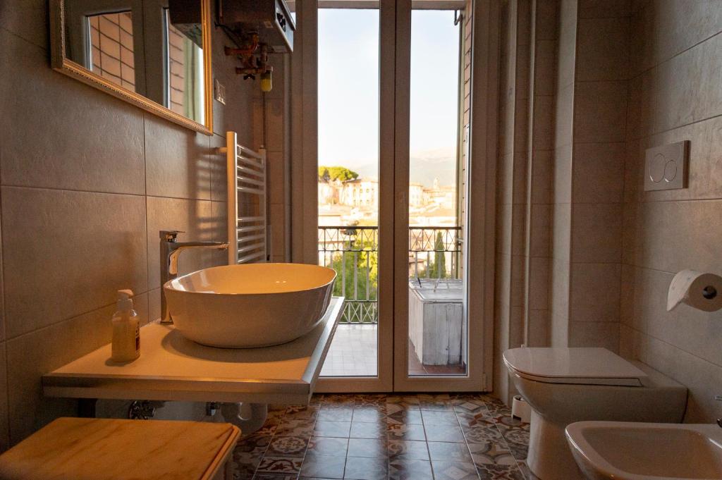 a bathroom with a large bowl sink and a window at Orchidee apartment in Rieti