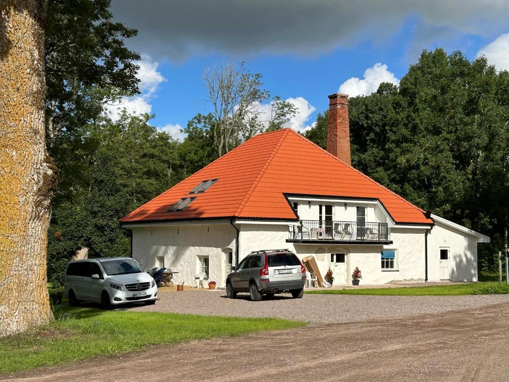 twee auto's geparkeerd voor een huis met een oranje dak bij Moderne Wohnung :: traumhafte Natur in Moholm