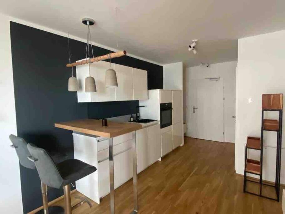 una cocina con armarios blancos y una pared negra en Moderne Wohnung in der Toplage inkl. Garage en Viena