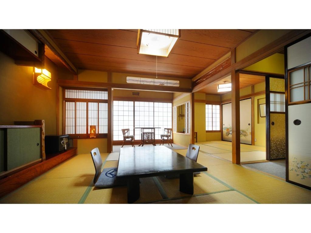 福島市にあるHotel Tenryukaku - Vacation STAY 16421vのテーブルと椅子が備わる広い客室です。