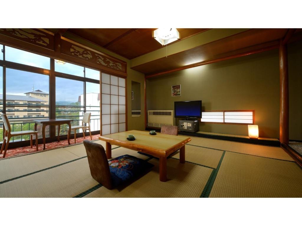 Hotel Tenryukaku - Vacation STAY 16390v في فوكوشيما: غرفة معيشة مع طاولة وشرفة
