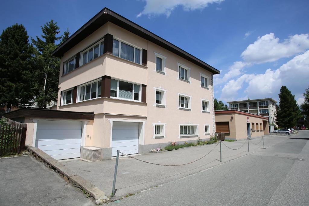 uma grande casa branca ao lado de uma rua em Haus Pyrola em Davos