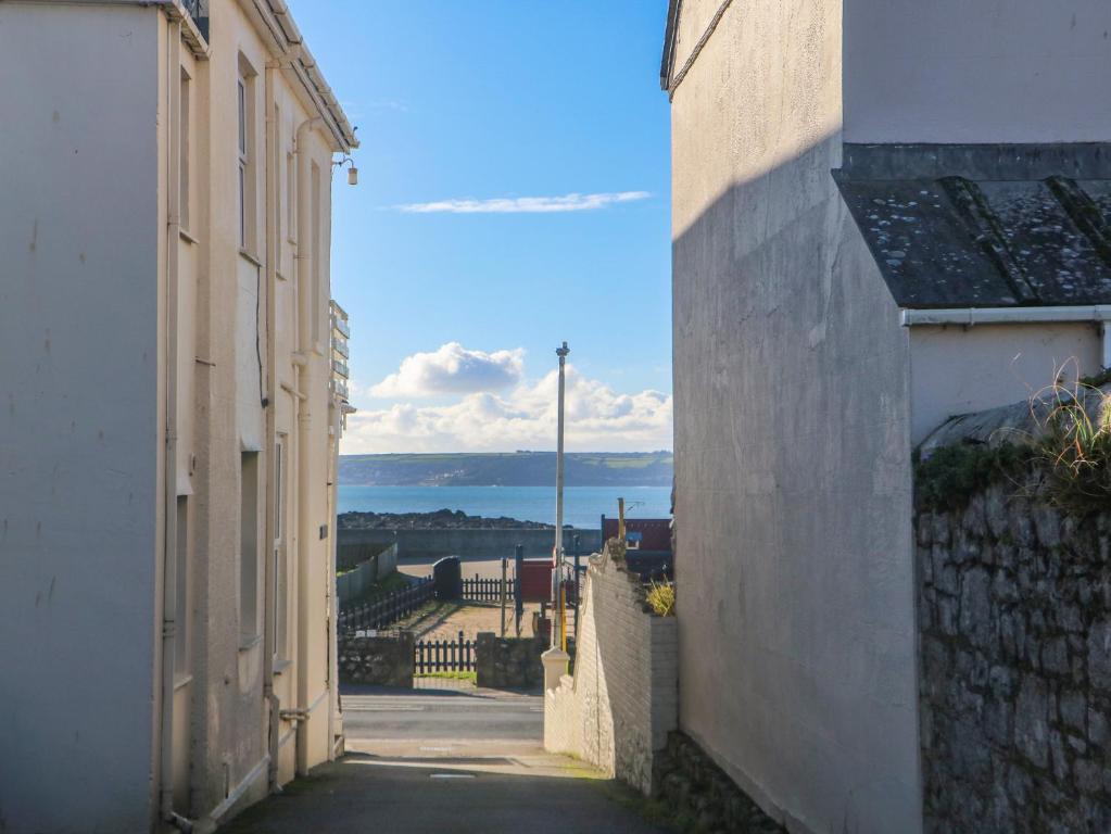 an alley between two buildings with a view of the ocean at Mackerel Sky in Marazion