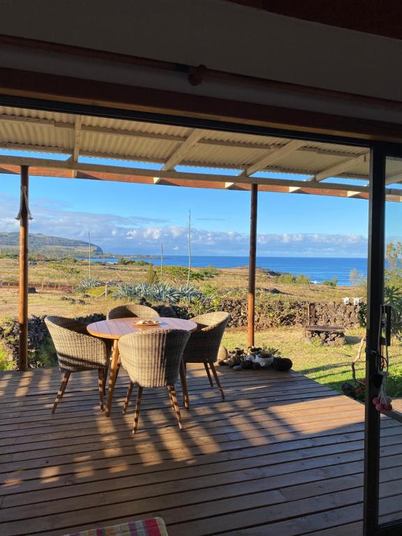 una mesa y sillas en una terraza con vistas al océano en Oasis Rapanui Bungalow frente al Mar, en Hanga Roa