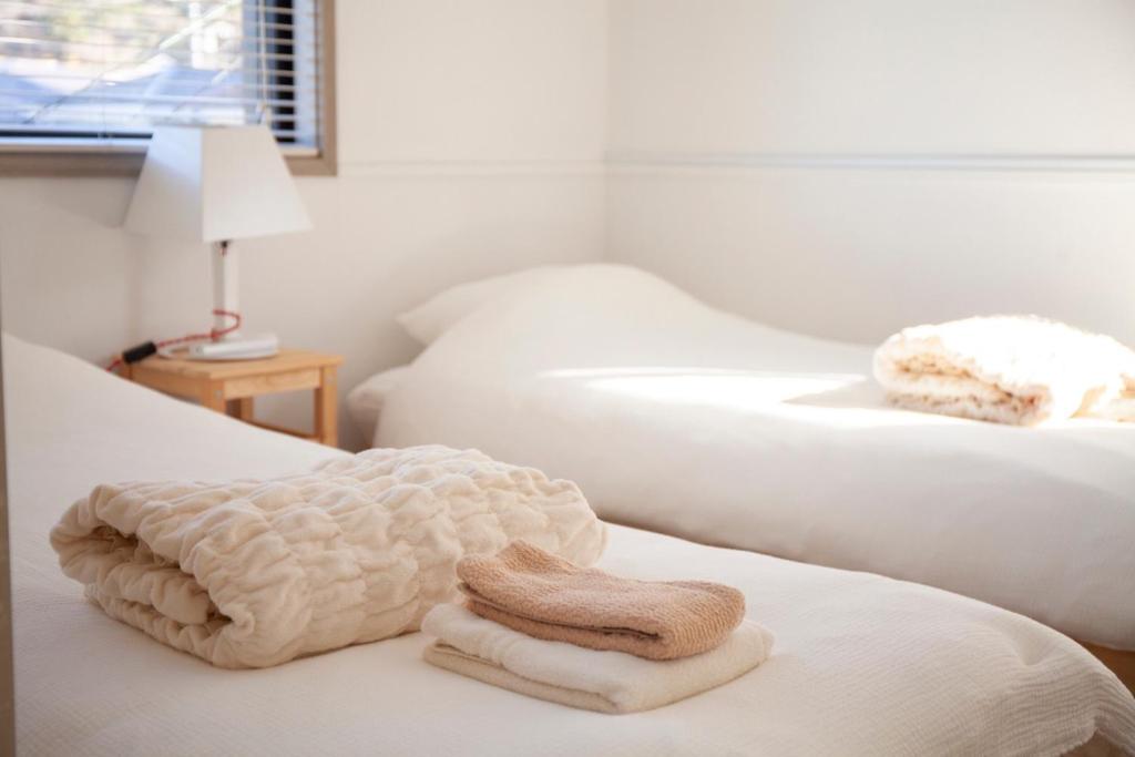 a room with two beds with towels on them at Cachtte Nagisa - Vacation STAY 95387v in Zushi