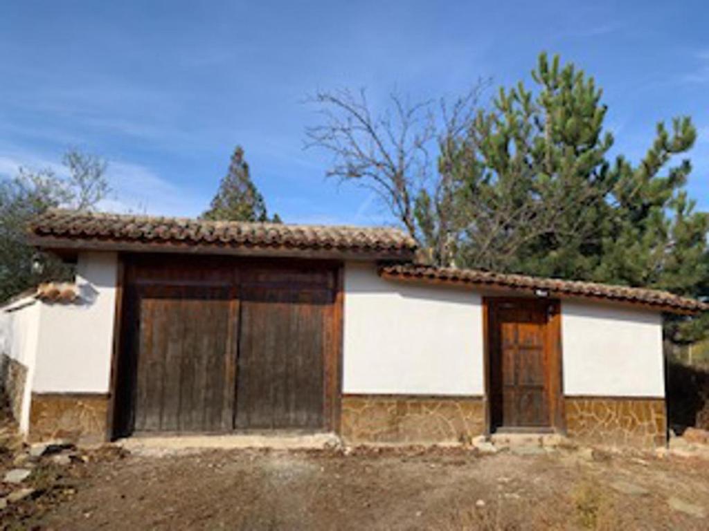 una pequeña casa con dos puertas en un campo en Captivating 3-Bed House in Ognen, en Ognen