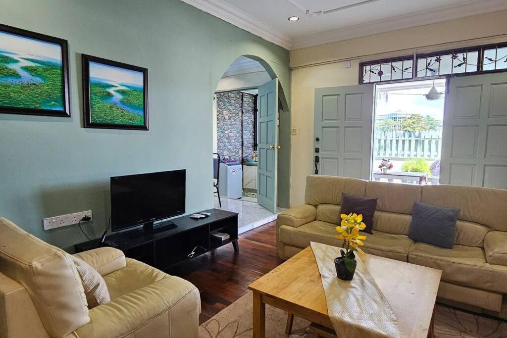 a living room with two couches and a tv at Kenyalang Piasau Homestay in Miri