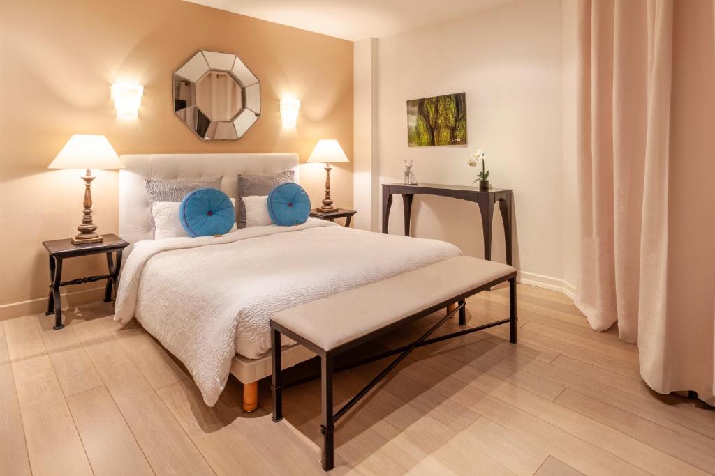 ein Schlafzimmer mit einem großen Bett mit blauen Kissen in der Unterkunft Providence Hotel in Vittel