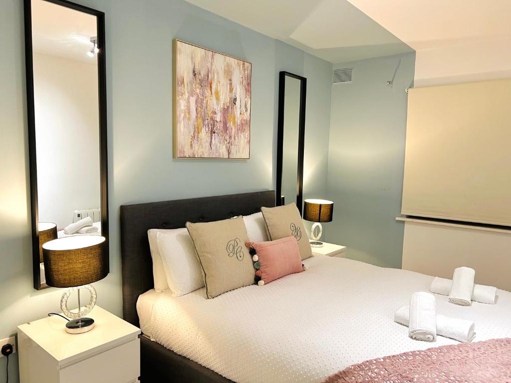 a bedroom with a bed with pink and white pillows at Luxury Flat at Temple Bar Dublin in Dublin