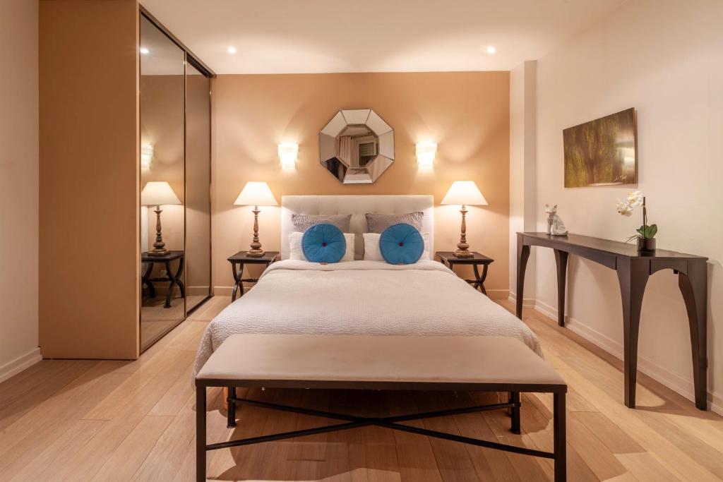 ein Schlafzimmer mit einem großen Bett und blauen Kissen in der Unterkunft Providence Hotel in Vittel