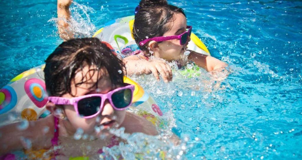 two children in a swimming pool wearing sunglasses at Encontro das Águas e Evian Caldas Novas in Caldas Novas