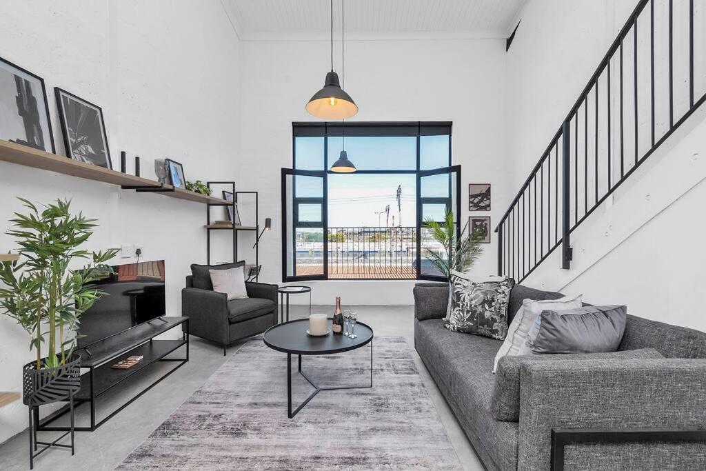 a living room with a couch and a table at Spice Yard Lofts on Voortrekker-B116 in Cape Town