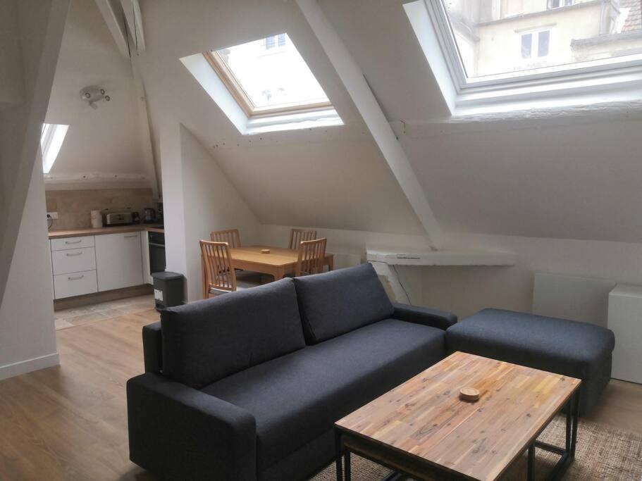 un salon avec un canapé et une table dans l'établissement Quartier historique de Mantes, au pied de la cathédrale avec vue directe sur celle-ci, à Mantes-la-Jolie