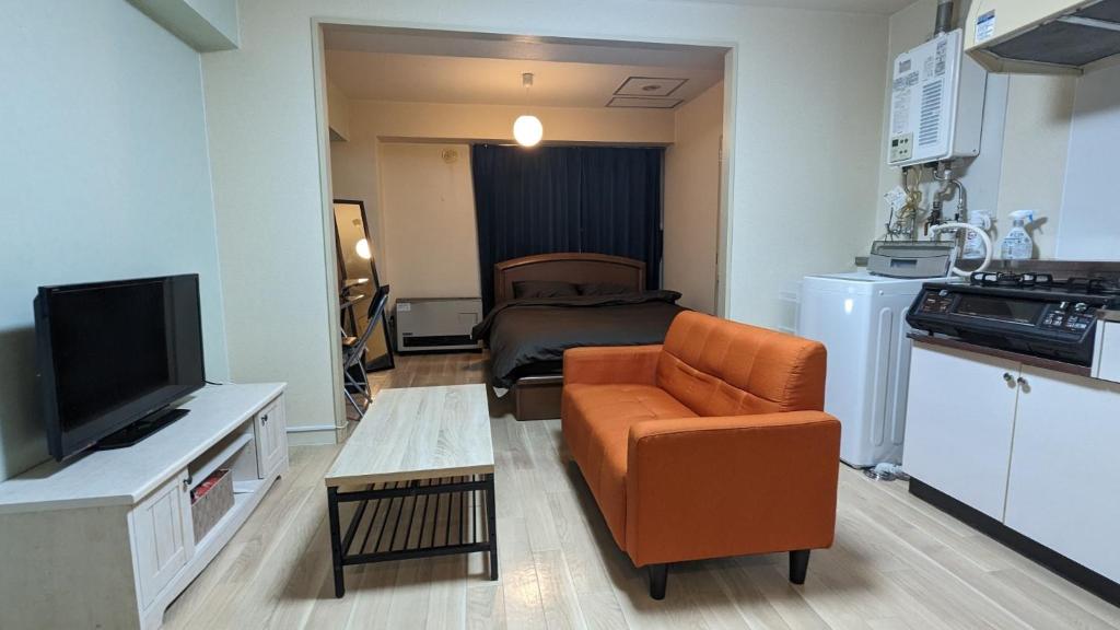 een kleine woonkamer met een bank en een televisie bij Space Minami 4jo - Vacation STAY 15808 in Sapporo