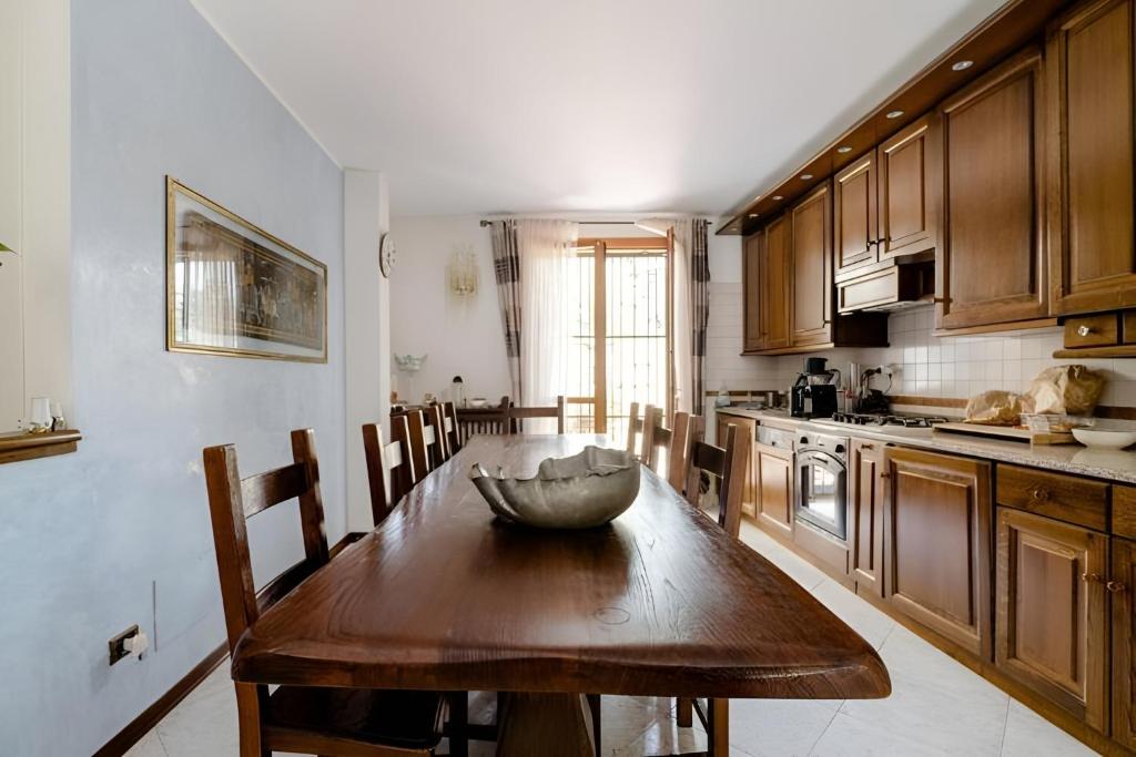 una cocina con una mesa de madera con un tazón. en Garden House Fiera Milano, en Pero
