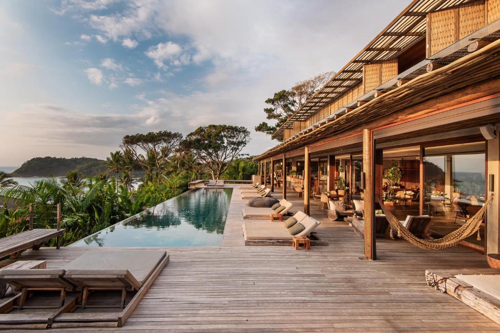 un resort con piscina e terrazza con sedie a sdraio di Barracuda Hotel & Villas a Itacaré