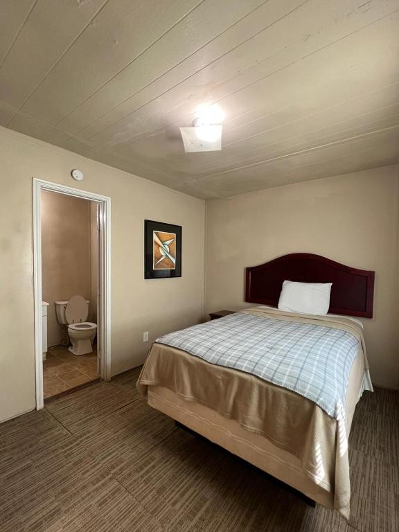 a bedroom with a bed and a bathroom with a toilet at Extended Stay of Carrizo Springs in Carrizo Springs