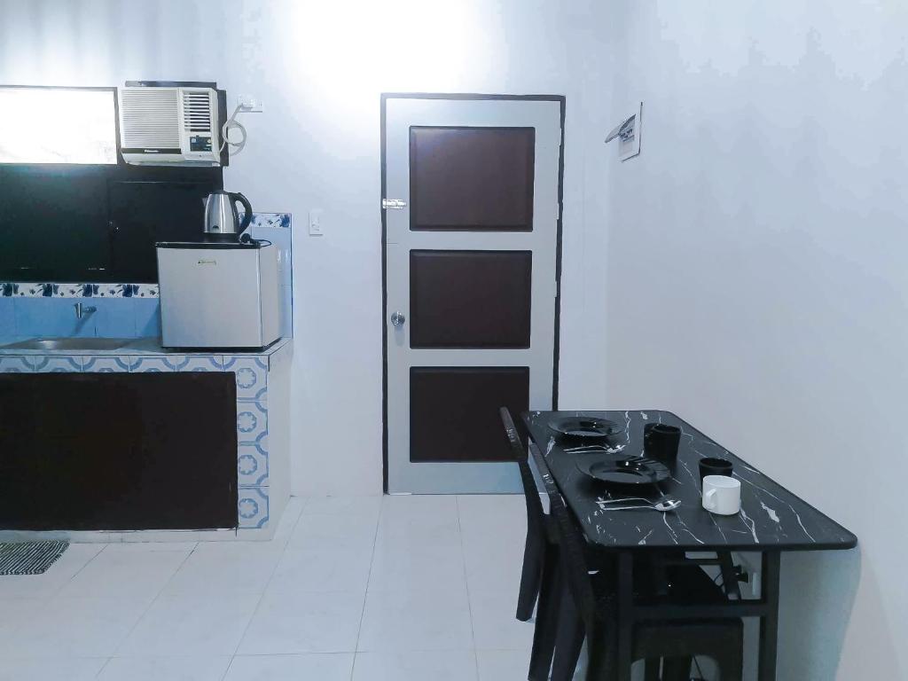 a black table in a kitchen with a door at Sleep, Eat, Relax with Serenity in Lucena