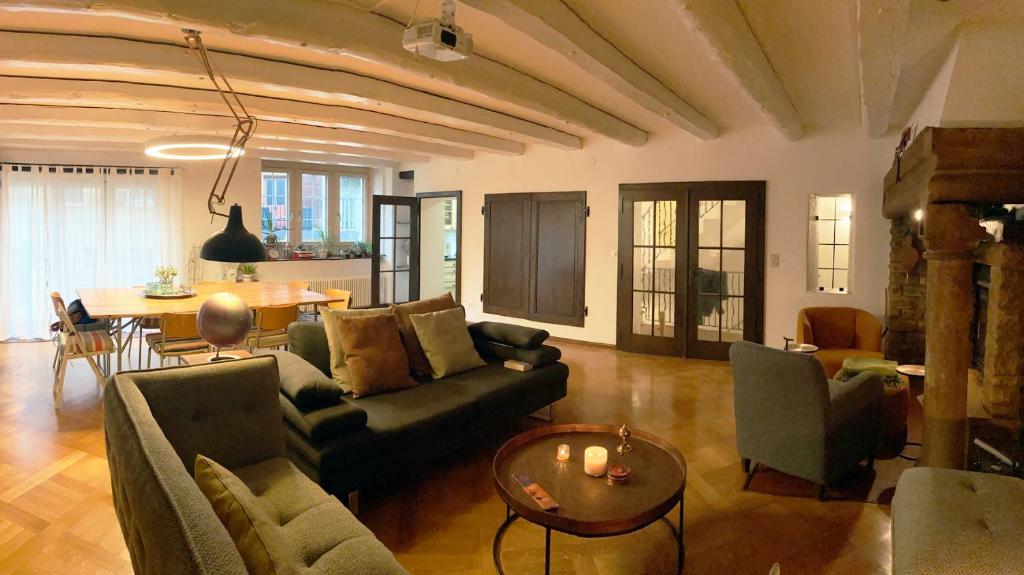 sala de estar con sofá y mesa en Ancienne Maison Vigneronne, en Hauterive