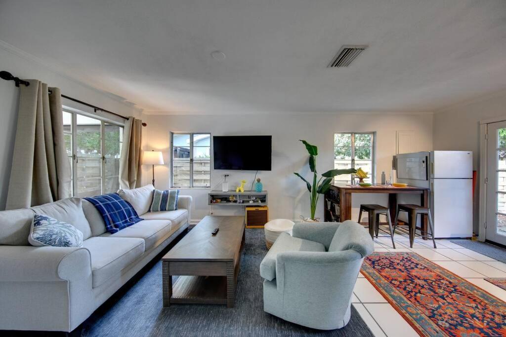 a living room with a white couch and a table at Charming old Florida home 15 mins from beaches in Sarasota