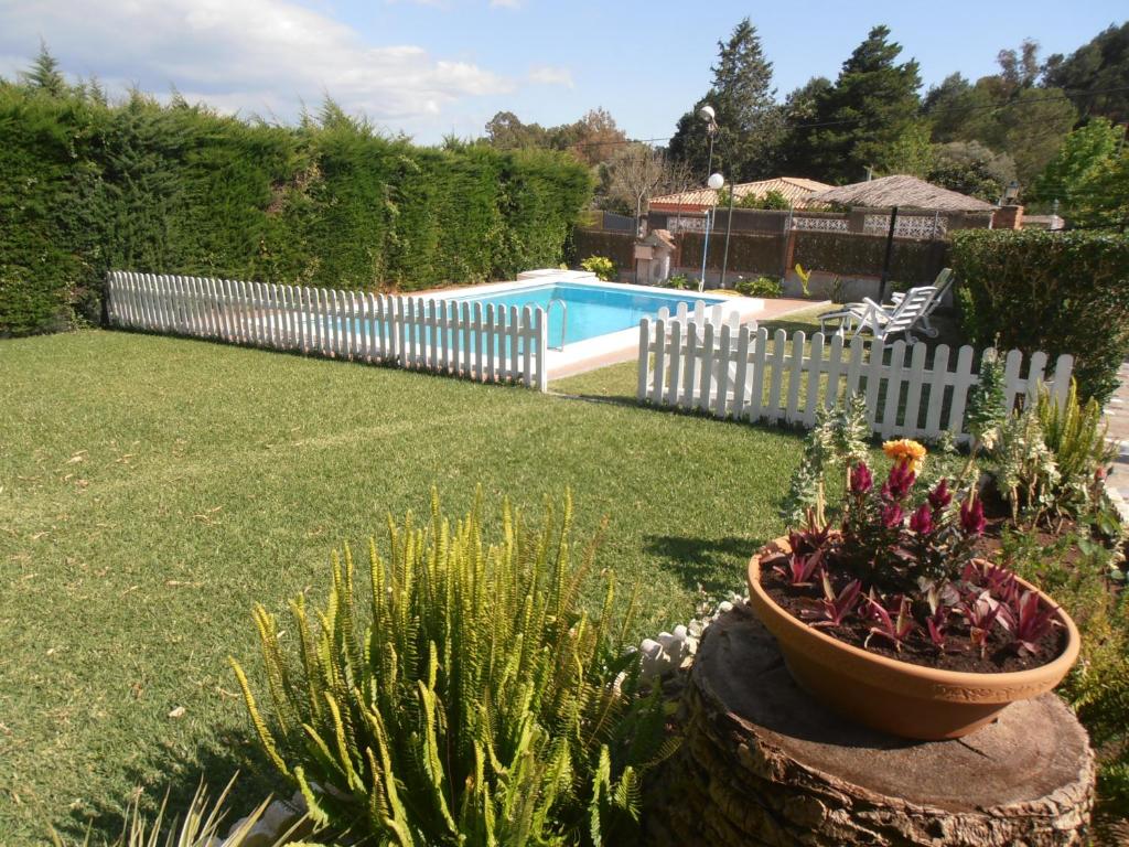 a yard with a fence and a pot of flowers at Chalet Playa de Barbate in Vejer de la Frontera