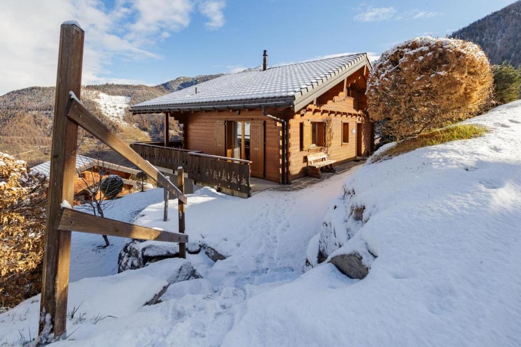 a log cabin in the snow with a gate at Chalet Elbaz - Swiss Chalet with breathtaking views in La Tzoumaz