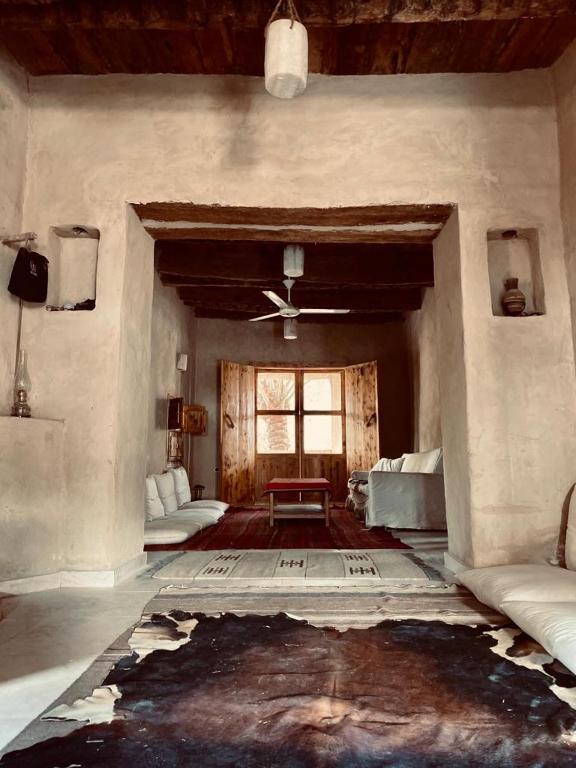 Siwa desert home في سيوة: غرفة معيشة مع كنب ومروحة سقف