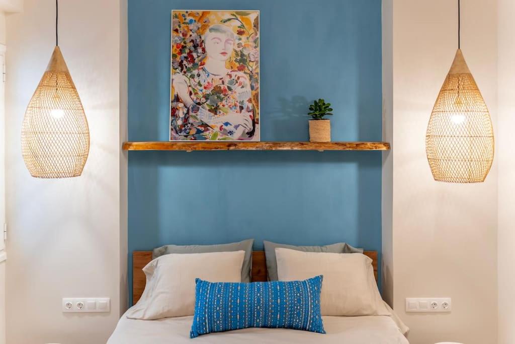 Un dormitorio con una pared azul y una cama con almohadas en Alios, Luxury Living Athens, en Atenas
