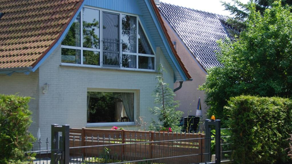 ein Haus mit einem Holzzaun davor in der Unterkunft Ferienhof Marlin - Ferienhaus Rügen in Solkendorf