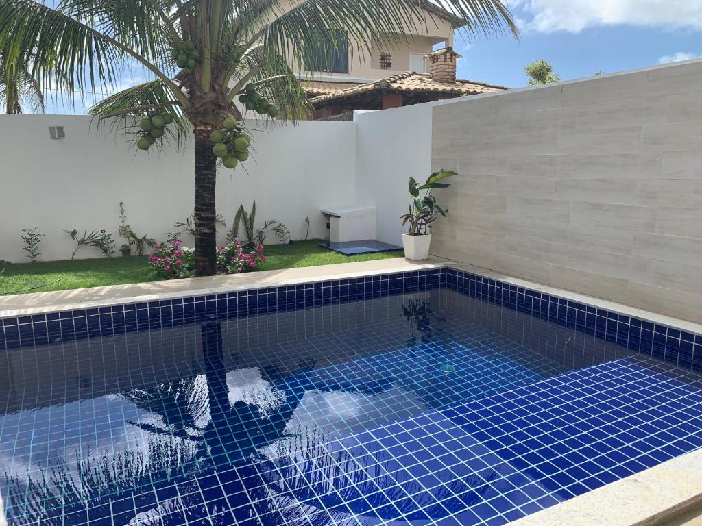 una piscina con suelo de baldosa azul y una casa en Reluz Tranquility melhorcasaaracaju, en Aracaju