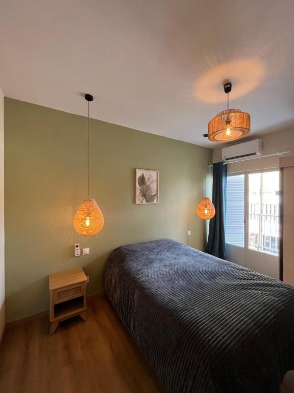 een slaapkamer met een bed en 2 verlichting bij La perle créole in Saint-Denis