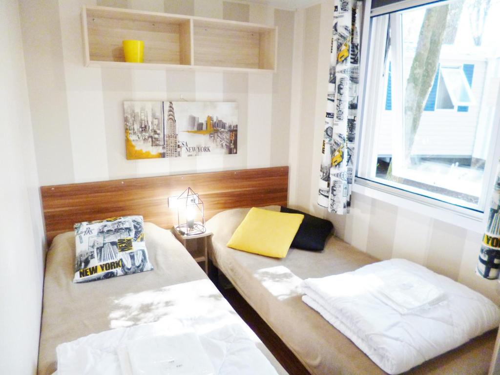 a small room with two beds and a window at HOME-COSY - 6 pers - 40 m2 3 CH - 2 SDB et 2 WC in Saint-Brevin-les-Pins