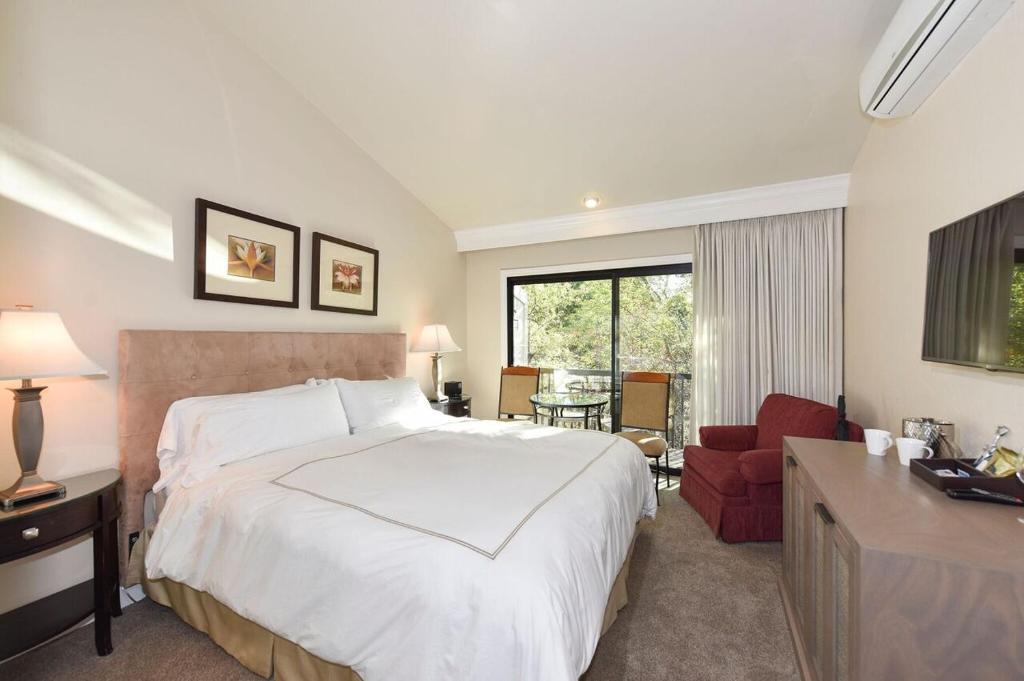 a bedroom with a large white bed and a red chair at Perfect Getaway Suite at Silverado in Napa
